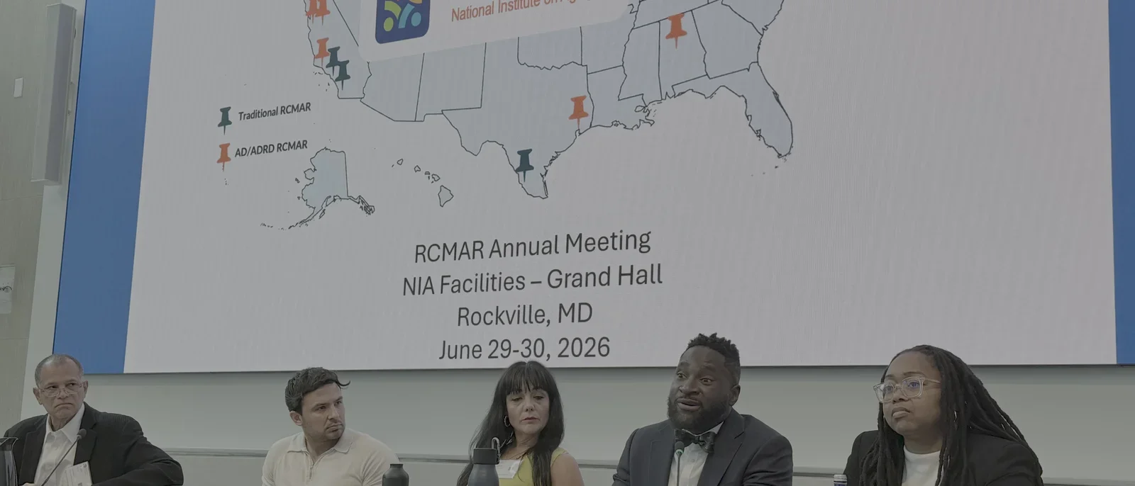 4 people at panel table with RCMAR poster of the US map