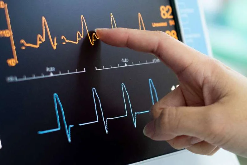 Finger pointing at heart monitor