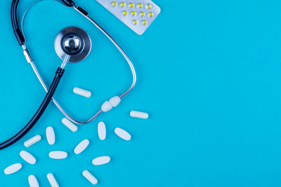 Stethoscope with pills scattered around.